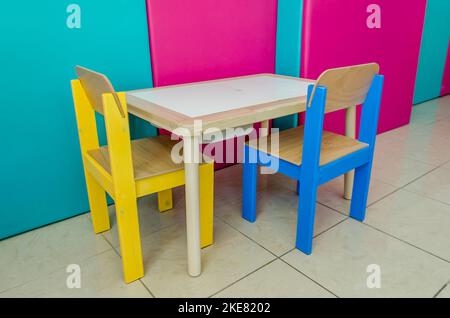 Ensemble de meubles en bois de table et chaises pour enfants multicolores. Lieu d'étude d'éducation spéciale pour les tout-petits dans une classe d'ergothérapie. Banque D'Images