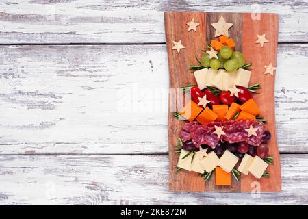 Tableau de charcuterie pour sapin de Noël. Vue ci-dessus sur un fond en bois blanc. Assortiment de fromages et hors-d'œuvre de viande. Banque D'Images