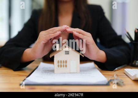 Mandataire, acheter et vendre des terrains, impôt foncier, montrer le concept de protéger la maison pour assurer le risque de dommages à la maison Banque D'Images