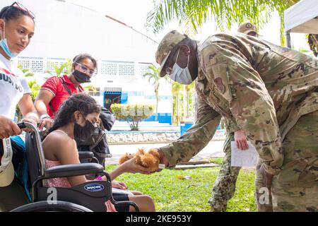 Puerto Barrios, Guatemala. 27th octobre 2022. Sgt. Principal Che Kinnard, 188th Medical Group Senior Enarted leader, donne à un bénéficiaire de soins un ours en peluche dans un site médical à Puerto Barrios, Guatemala, le 27 octobre 2022, pendant la promesse continue 2022. Les membres de la Garde nationale aérienne de l'Arkansas participent à la promesse continue 2022 de soutenir le Guatemala par le biais du Programme de partenariat avec l'État de la Garde nationale des États-Unis, qui développe des relations avec les pays partenaires tout en fournissant un soutien tel que des soins médicaux et une meilleure préparation des forces américaines et partenaires. (Photo par le sergent d'état-major. Chris Banque D'Images