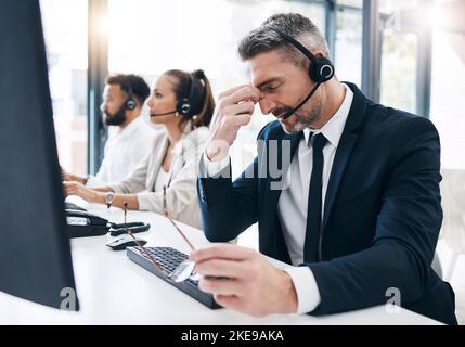 Centre d'appels, service à la clientèle et homme souffrant de maux de tête, de stress et fatigué de travailler au bureau. Burnout, crm et un consultant en télémarketing frustré de sexe masculin Banque D'Images