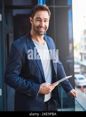 L'air frais empêche mes idées de périmées. Un homme d'affaires utilisant sa tablette tout en se tenant debout sur un balcon. Banque D'Images