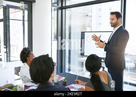 Une présentation parfaite. Un homme d'affaires qui donne une présentation dans la salle de réunion. Banque D'Images