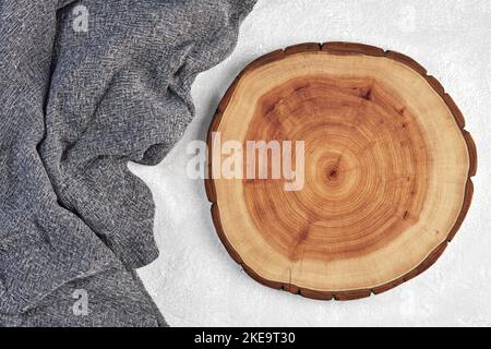 Planche à découper en bois ou dessous de verre et serviette de cuisine grise sur un Banque D'Images