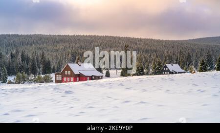 Paysage hivernal des montagnes de Jizera. Prés enneigés et ancienne maison en bois par temps froid d'hiver. Jizerka, République tchèque. Banque D'Images