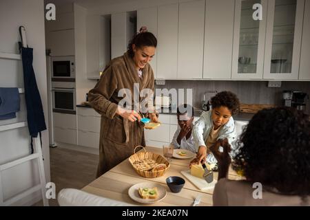 Les mères et les fils mangent le petit-déjeuner Banque D'Images