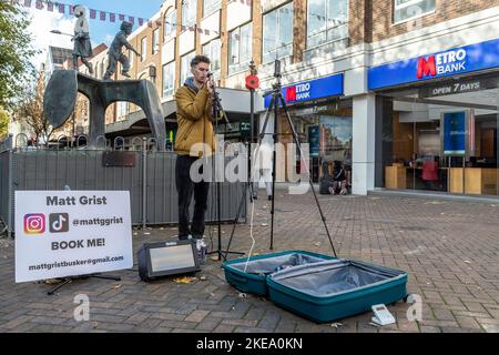 Busker près de The Cobblers Last, stuatue dans la rue Abington par Graham Ibbeson artiste et sculpteur britannique, Abington Street, Northampton, Angleterre, Royaume-Uni. Banque D'Images