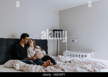 Femme enceinte avec partenaire au lit Banque D'Images