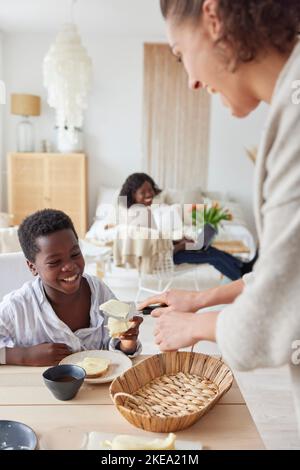 Famille travaillant et prenant un repas à la maison Banque D'Images