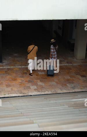 Un couple multiethnique inhabituel entre dans le centre commercial souterrain après leur arrivée en ville Banque D'Images