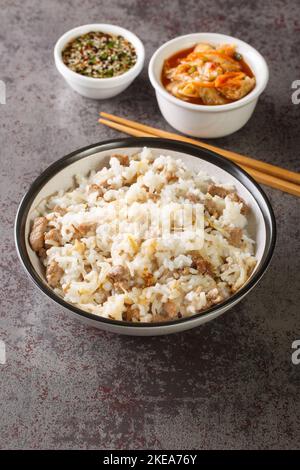 Riz coréen avec pousses de soja et viande servi avec sauce Yangnyumjang et kimchi en gros plan sur la table. Verticale Banque D'Images