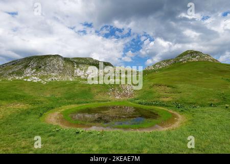 Montagnes de Zelengora dans le parc national de Sutjeska. Petit étang dans la vallée entouré de montagnes. La vie de randonnée. Voyage et aventure. Camping. Banque D'Images