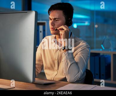 Homme d'affaires, télémarketing et conseil travaillant la nuit au bureau pour le service à la clientèle ou les conseils. Homme en contact avec nous, consultation ou aide avec Banque D'Images