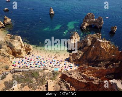 Vue aérienne de drone sur la plage animée de Camilo à Lagos, Algarve, Portugal pendant les vacances d'été. Destinations incroyables. Voyage et aventure. Vacances. Banque D'Images