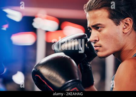 Fitness, profil et boxer en salle de gym pour le match ou la compétition. Vue latérale, sports de boxe ou athlète masculin sérieux dans le centre de fitness pratiquant Banque D'Images