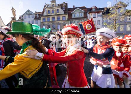 Erfurt, Allemagne. 11th novembre 2022. Des fous dansent devant l'hôtel de ville. Au début de la saison du carnaval, l'Association du Carnaval d'Erfurt (GEC) célèbre les Narrenwecken sur le marché du poisson. Credit: Michael Reichel/dpa/Alay Live News Banque D'Images