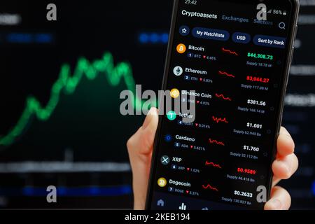 Ukraine, Odessa - octobre 9 2021 : main tenant mobile avec l'application CoinMarketCap fonctionnant sur l'écran de smartphone avec la liste des prix de crypto-monnaie actuels, Banque D'Images