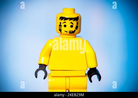 figurine lego jaune avec joie sur son visage sur fond bleu avec une vignette. Photo de haute qualité Banque D'Images