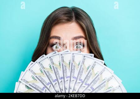 Gros plan photo de jeune excitée positive mignon dame cache face beaucoup de dollars enjoué childish riche succès d'affaires isolé sur la couleur de l'aigue-marine Banque D'Images