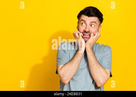 Portrait photo de jeune drôle nerveux impressionné homme choqué mordre doigts échec de gestionnaire erreur look vide espace isolé sur fond jaune couleur Banque D'Images