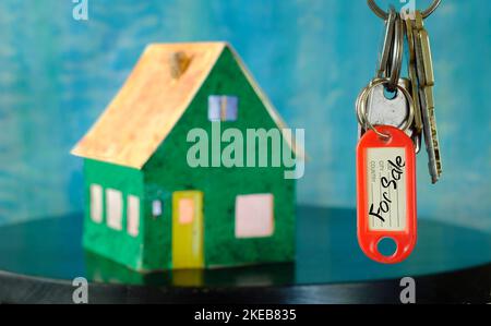 Latchkey avec porte-clés et flou de maison dans le dos, maison d'achat, concept immobilier.Focus sélectif, espace de copie libre Banque D'Images