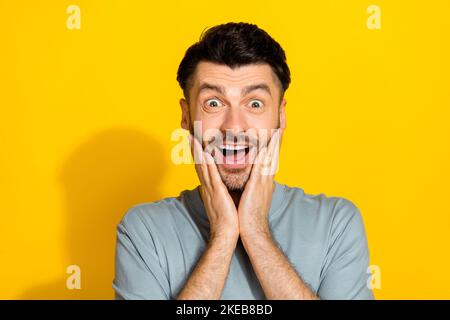 Gros plan photo de jeune excitée funky homme toucher joues choqué comment bas prix centre commercial demain grande vente offre isolée sur fond jaune couleur Banque D'Images