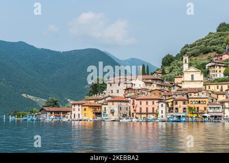 Monte Isola, Italie - 05-06-2022: Paysage du lac de Peshiera Maraglio à Monte Isola avec de belles maisons colorées reflétant dans l'eau Banque D'Images