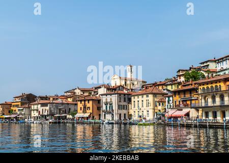 Monte Isola, Italie - 05-06-2022: Paysage du lac de Peshiera Maraglio à Monte Isola avec de belles maisons colorées reflétant dans l'eau Banque D'Images