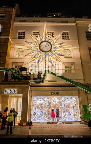 Londres, Royaume-Uni. 11th novembre 2022. Les lumières de Noël s'allument, avec l'aide des cueilleurs de cerisier, sur la façade de Dior au-dessus de New Bond Street. Crédit : Guy Bell/Alay Live News Banque D'Images