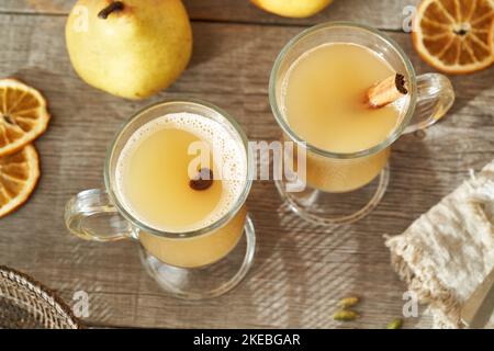 Deux verres de boisson chaude faite maison à la poire avec de la cannelle sur une table en bois Banque D'Images