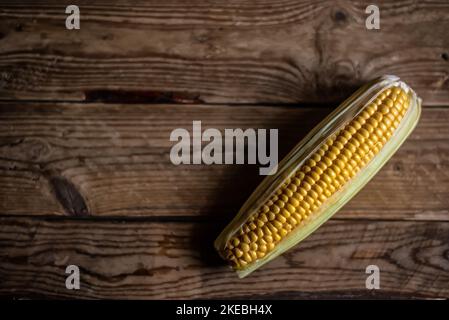 Épis de maïs (Zea mays) sur fond de bois rustique. Vue de dessus avec espace de copie. Banque D'Images