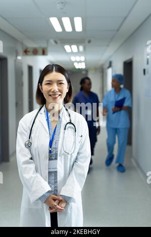 Portrait vertical d'une femme asiatique souriante médecin dans le couloir de l'hôpital, espace de copie Banque D'Images