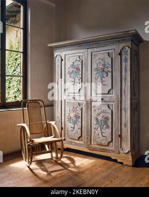 gros plan sur une vieille armoire décorée d'un fauteuil à bascule le sol est en bois Banque D'Images