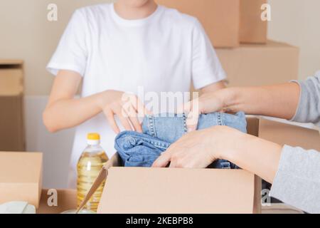Les bénévoles collectent des dons pour des œuvres de bienfaisance à l'intérieur. Boîtes de dons avec vêtements, nourriture, produits d'hygiène. Don, charité, banque alimentaire, aide aux pauvres Banque D'Images