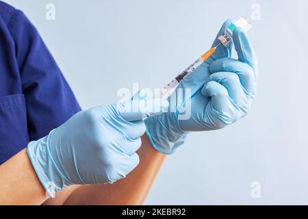 Médecin en gants bleus préparant la seringue pour l'injection. Concepts de vaccination Banque D'Images