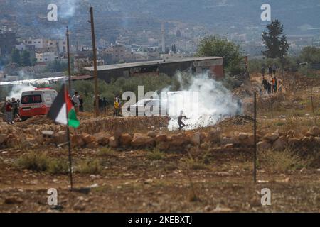 Naplouse, Palestine. 11th novembre 2022. Un manifestant palestinien s'enfuit des canisters à gaz lacrymogènes tirés par les forces israéliennes lors de la manifestation contre les colonies israéliennes dans le village de Beit Dajan, près de la ville de Naplouse, en Cisjordanie. (Photo de Nasser Ishtayeh/SOPA Images/Sipa USA) crédit: SIPA USA/Alay Live News Banque D'Images