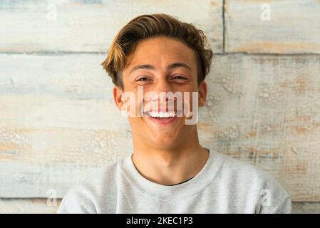 gros plan de beau adolescent souriant et riant seul à accueil - portrait du visage du jeune homme Banque D'Images