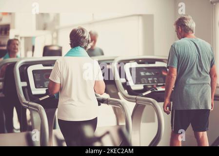 couple de deux séniros actifs faisant de l'exercice ensemble à la salle de gym - course et marche à l'intérieur - fitness et concept de style de vie sain Banque D'Images
