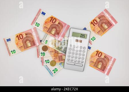 Studio tiré du dessus d'une calculatrice avec des billets et des pièces en euros comme espèces et de changement lâche Banque D'Images