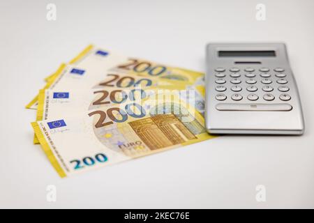 200 billets en euros et calculatrice comme symbole de richesse photographiés du côté avec une faible profondeur de champ Banque D'Images