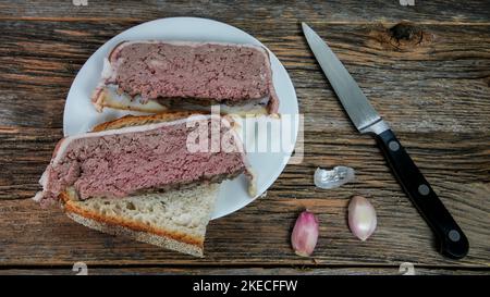 Pâté fait maison enveloppé de bacon de porc et de foie sur une table rustique Banque D'Images