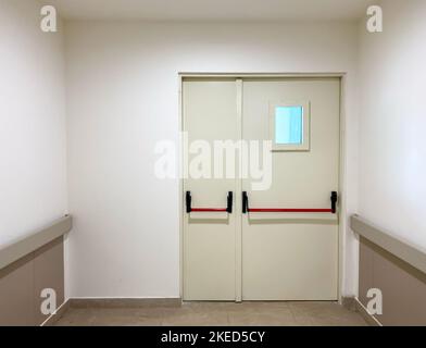 porte de sortie de secours au bout du couloir. Porte et mur blancs. Mise au point sélective Banque D'Images