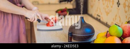 BANNER, FEMME DE FORMAT LONG prépare la nourriture à côté d'un diffuseur d'arôme. Cuire coupe des poivrons rouges mûrs dans la cuisine. Cuisson de salade de poivrons frais, mûrs Banque D'Images
