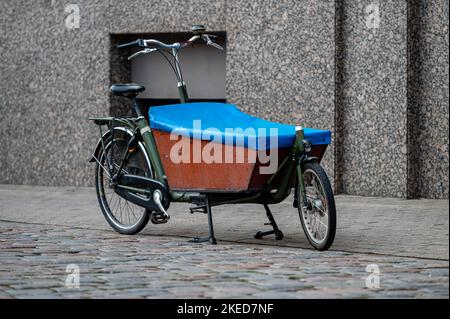 Un vélo de soute pour livraison rapide en ville est garé sur le trottoir devant la maison Banque D'Images