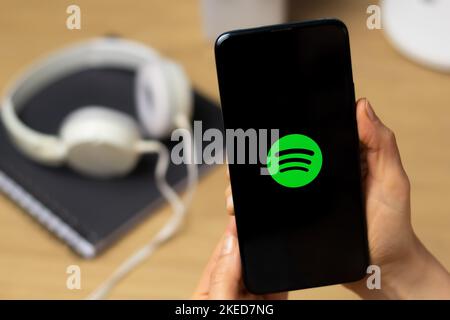 Kiev, Ukraine - 15th octobre 2022 : logo Spotify sur l'écran d'un smartphone entre les mains d'une femme. Service de streaming pour écouter de la musique. Banque D'Images
