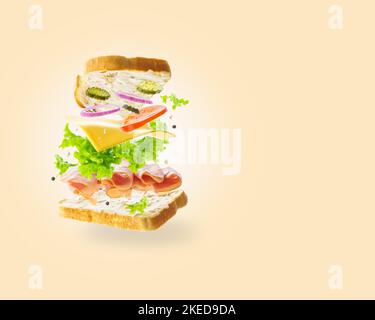 Composition culinaire créative. Sandwich américain appétissant avec de la viande et du fromage biologiques, des légumes frais dans un vol congelé sur fond beige. R Banque D'Images