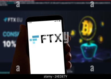 Dans cette illustration, le logo FTX de la société cryptographique en ligne s'affiche sur l'écran d'un smartphone avec une page d'accueil de site Web en arrière-plan. La plate-forme de trading de crypto-monnaie s'est classée en faillite après une chute soudaine de la valeur de ses actions. Banque D'Images