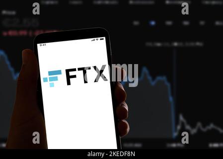 Espagne. 4th novembre 2021. Dans cette illustration, le logo FTX de la société cryptographique en ligne s'affiche sur l'écran d'un smartphone avec un graphique boursier en arrière-plan. La plate-forme de trading de crypto-monnaie s'est classée en faillite après une chute soudaine de la valeur de ses actions. (Image de crédit : © Davide Bonaldo/SOPA Images via ZUMA Press Wire) Banque D'Images