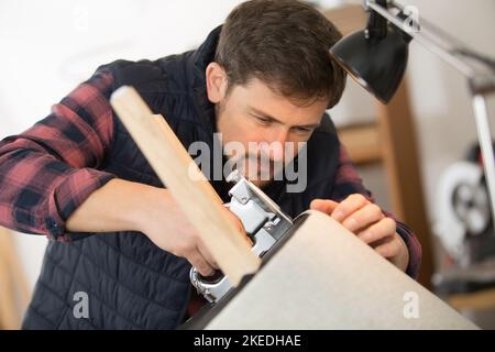 homme rembourrer un tabouret rond Banque D'Images