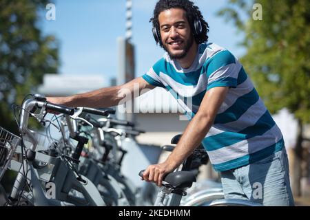 un jeune étudiant attrayant loue un vélo de ville Banque D'Images